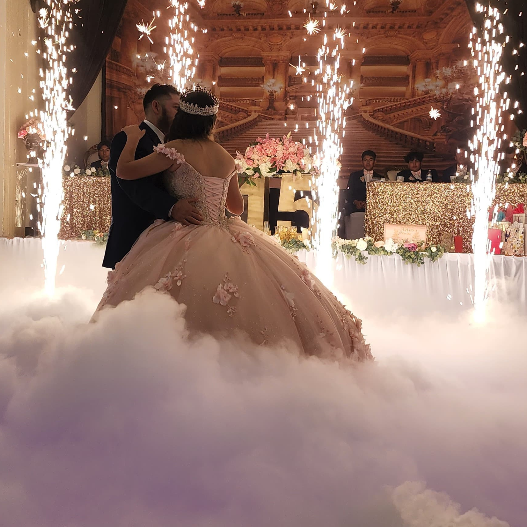 Quinceañera first dance with dry ice clouds and cold sparkler fountains in an ornate ballroom