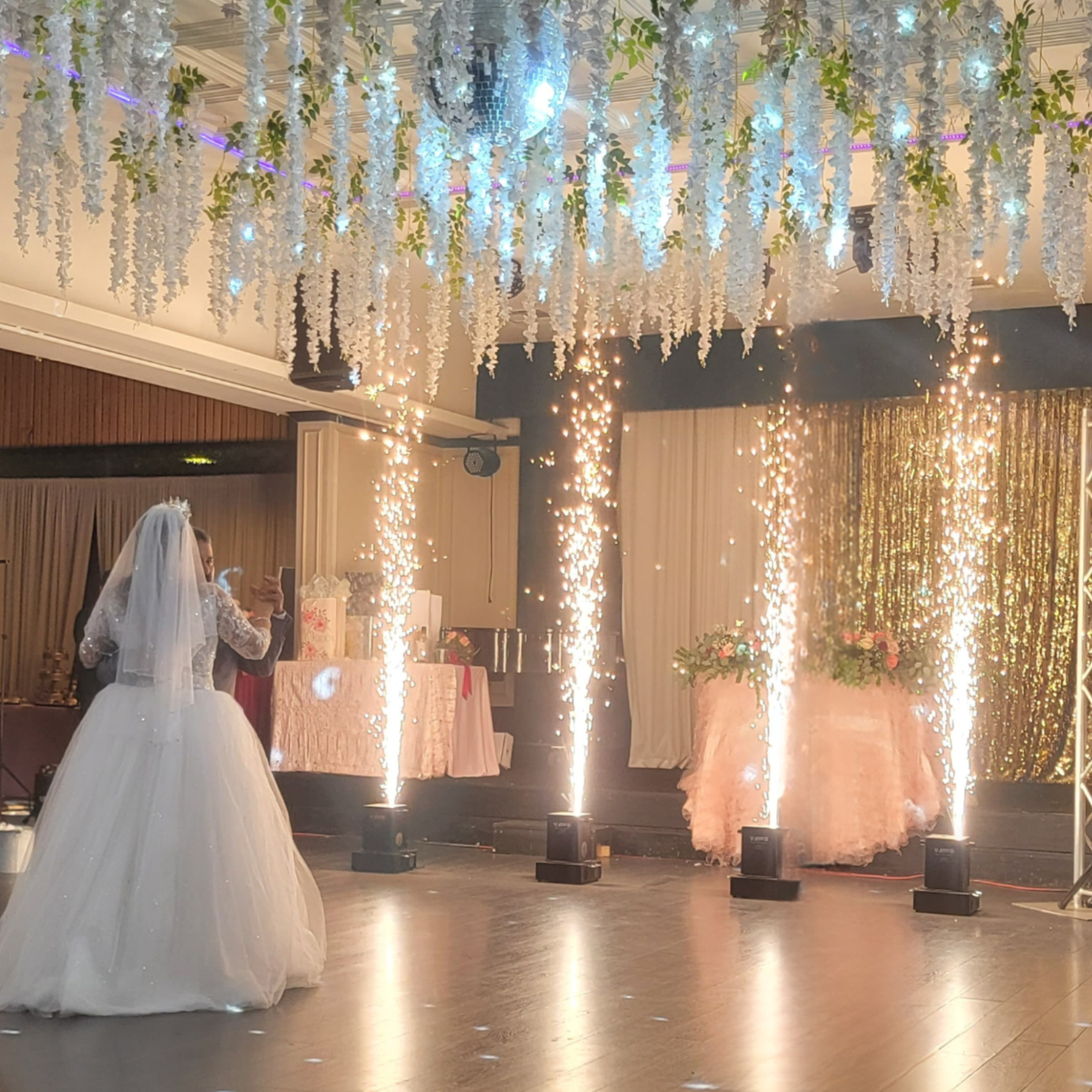 Wedding reception with hanging floral ceiling installation and sparkler fountains