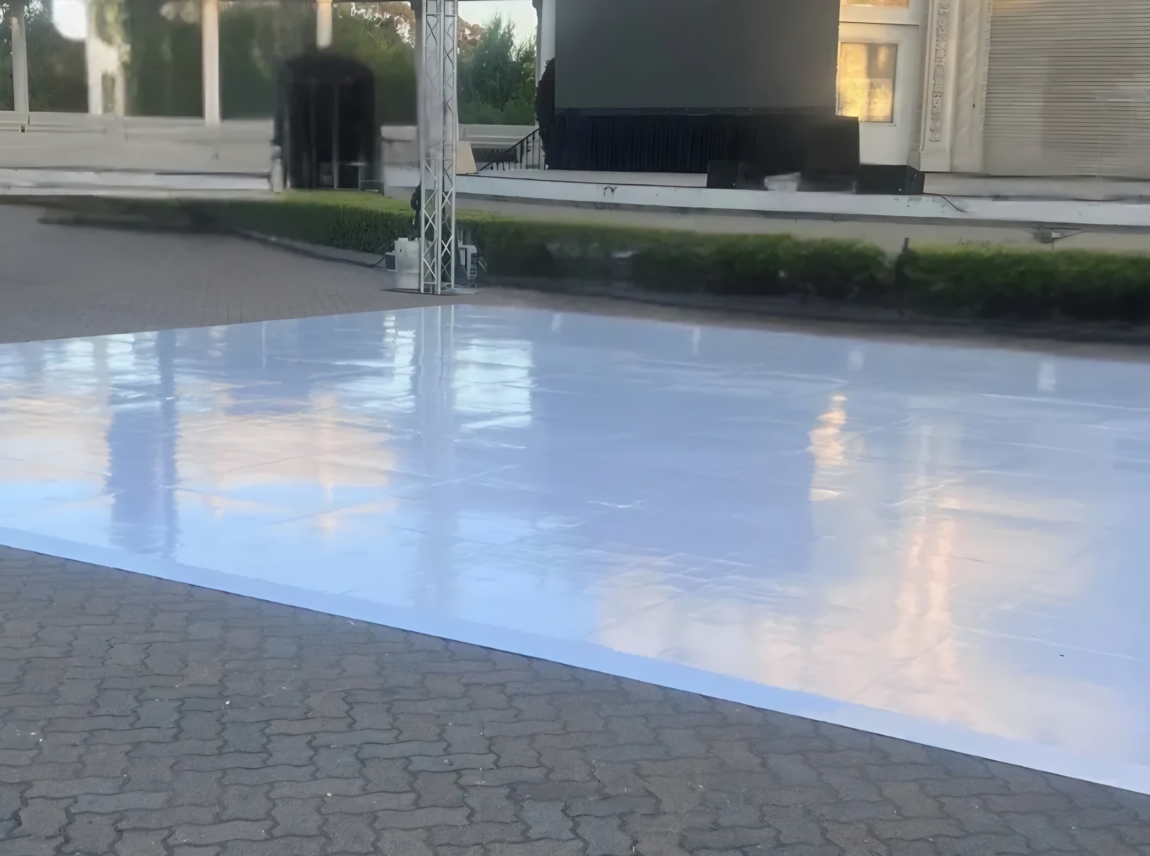Glossy white dance floor installed on outdoor patio at event venue